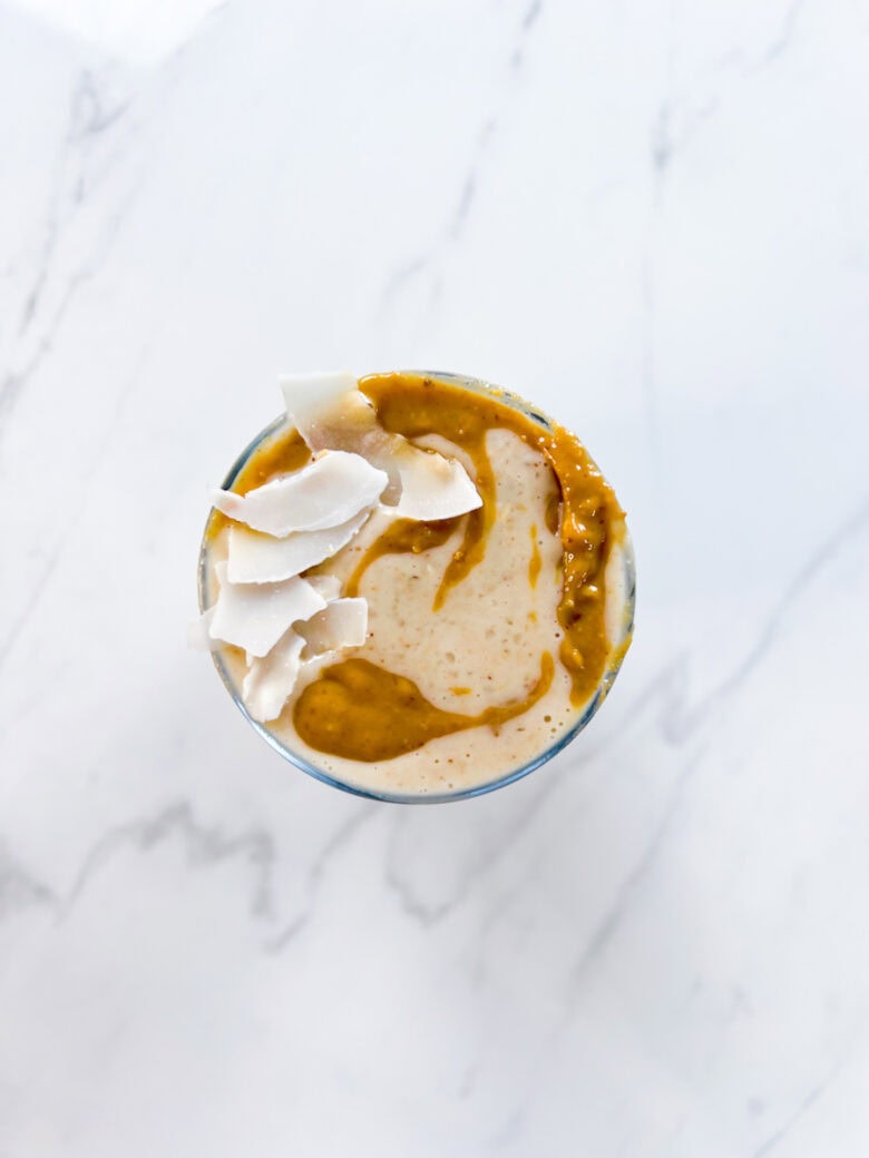 Peanut Butter Banana Date Smoothie topped with dried coconut.