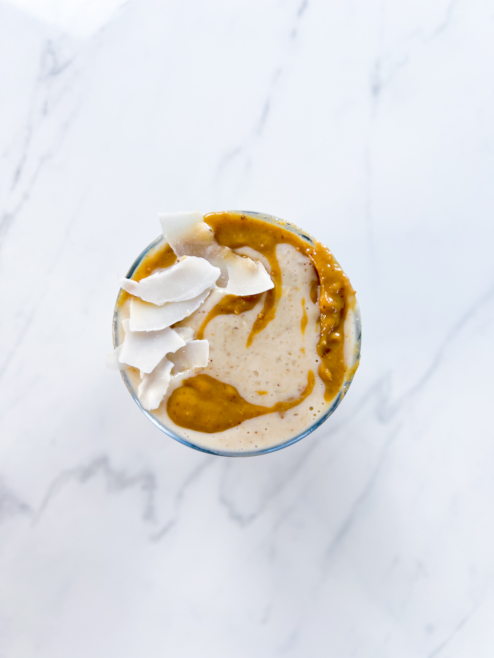 Peanut Butter Banana Date Smoothie with Coconut on top from above.
