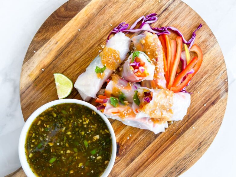 Spring Rolls on a cutting board with lime orange sauce