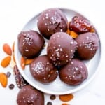 Chocolate balls on a white plate labeled chocolate date balls.