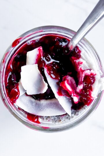 Chia pudding topped with berry compote and coconut flakes