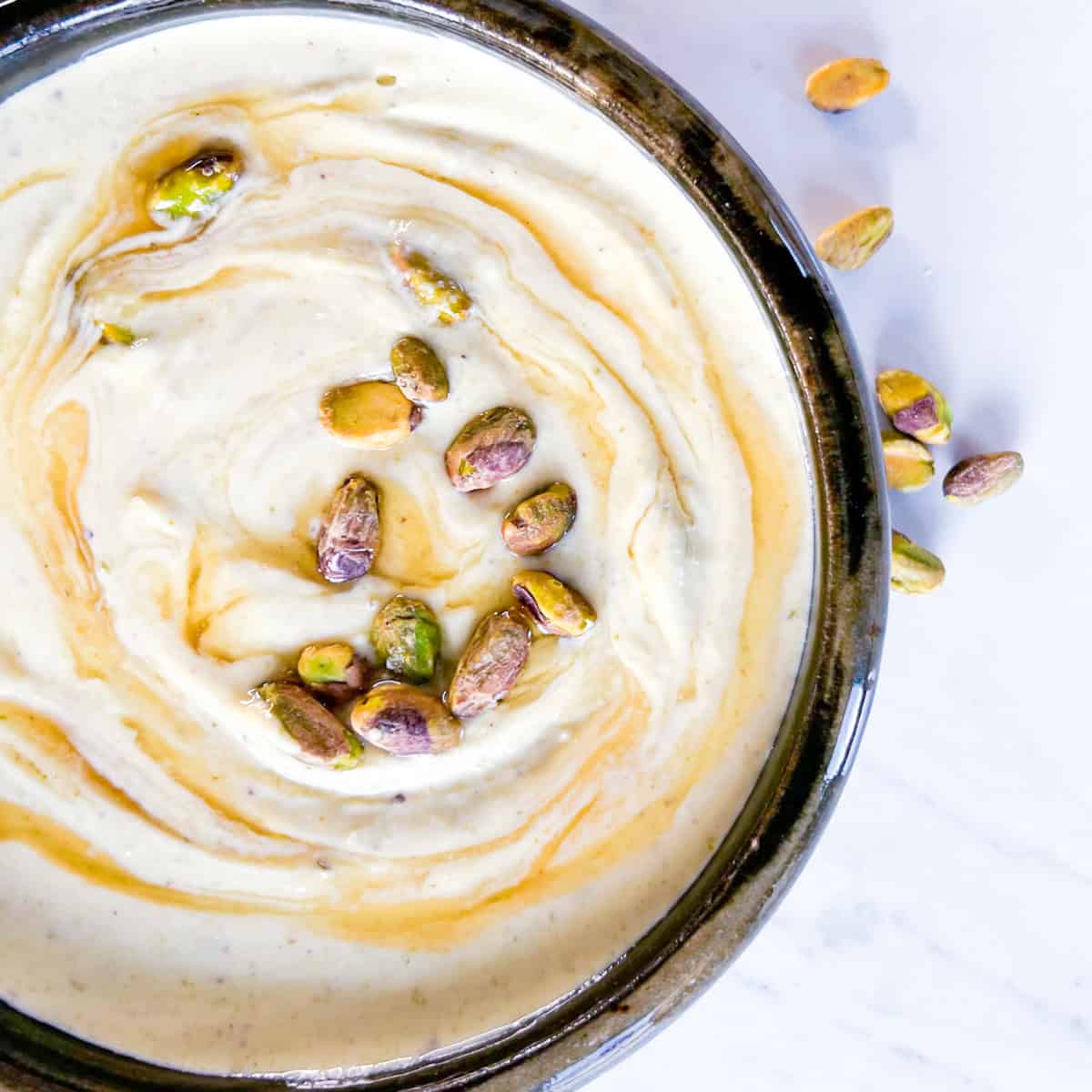 Honey whipped feta in a bowl topped with honey.