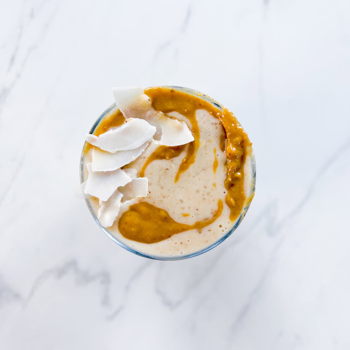 Peanut butter date smoothie topped with coconut.