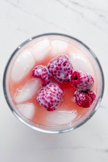 Pink drink topped with raspberries.