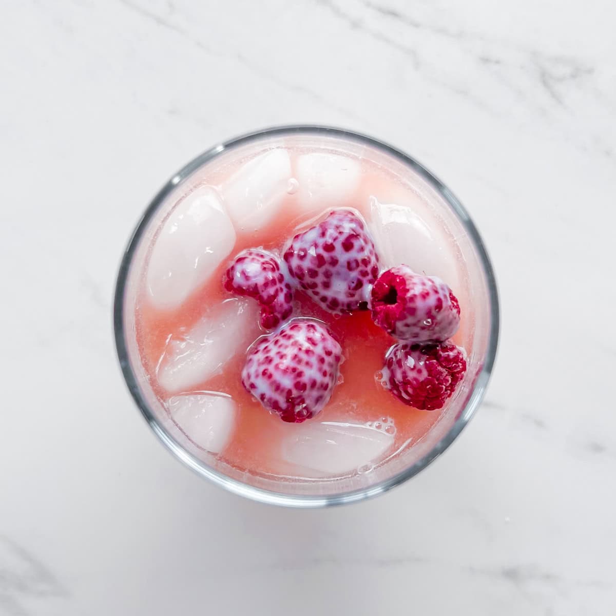 Pink drink topped with raspberries.