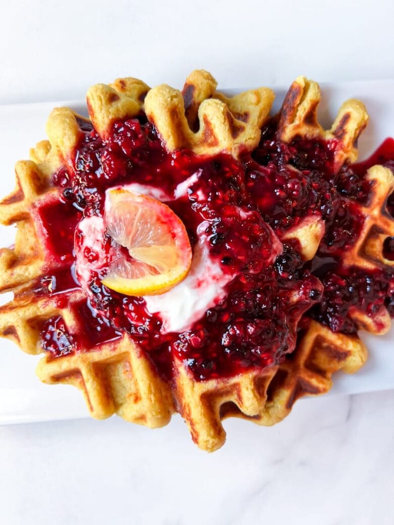 Oat flour waffles with berries on top.