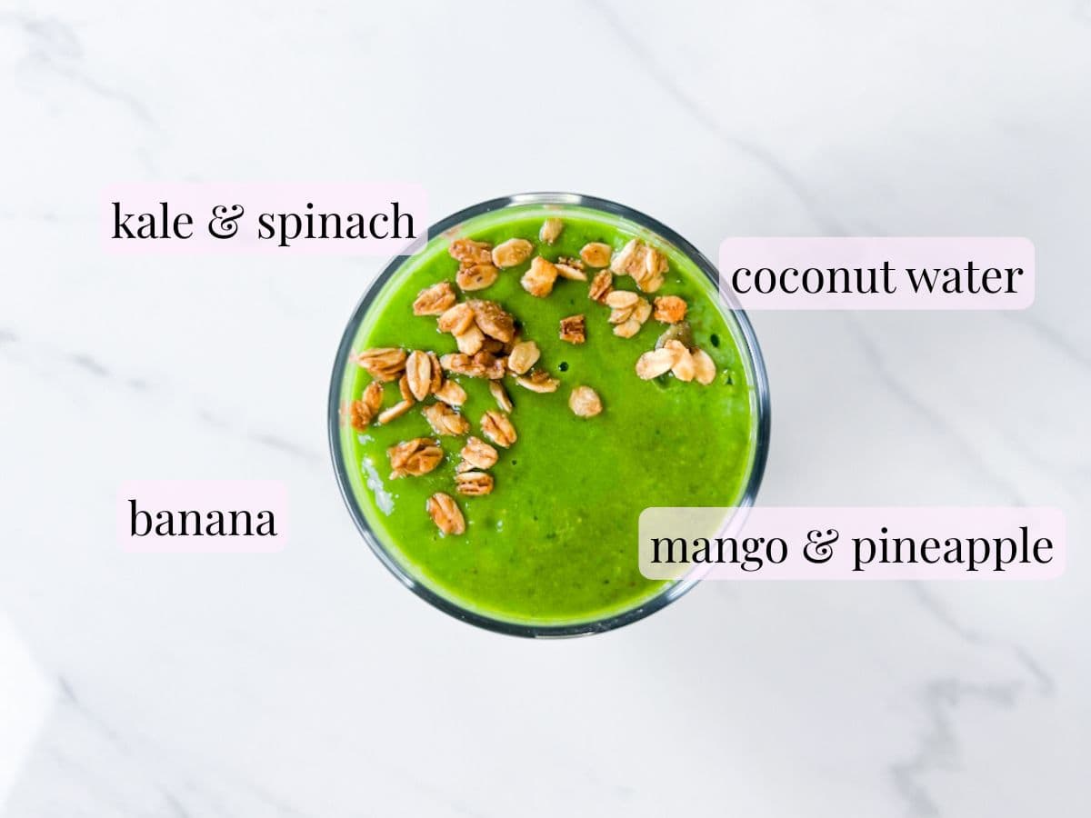Green smoothie in a cup with ingredients labeled.