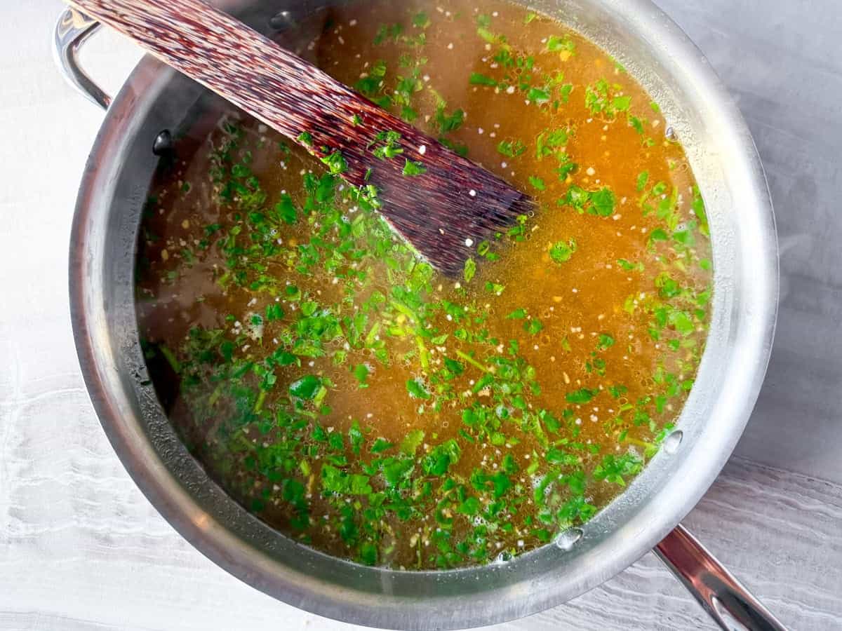Asian chicken noodle soup broth in the pot simmering.