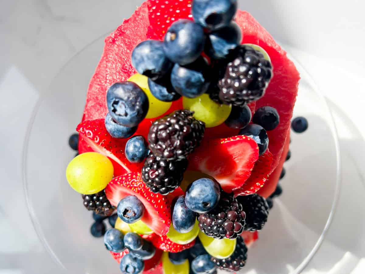 Finished watermelon cake topped with fresh berries and grapes.