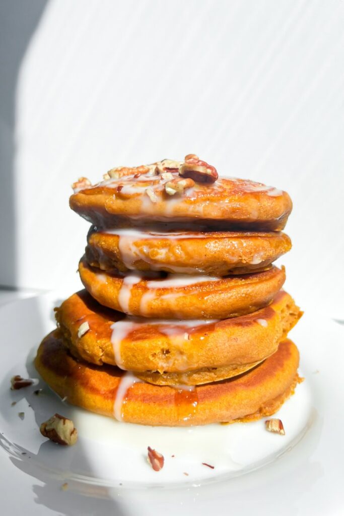 Stack of pancakes with pecans and coconut cream.