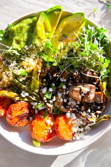 True food kitchen style bowl with quinoa, sweet potato, portobello mushroom, and microgreens.