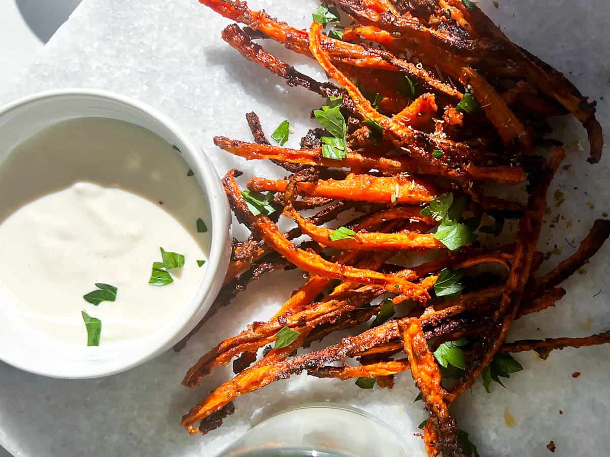 Roasted carrots with whipped feta in a bowl by the carrots.