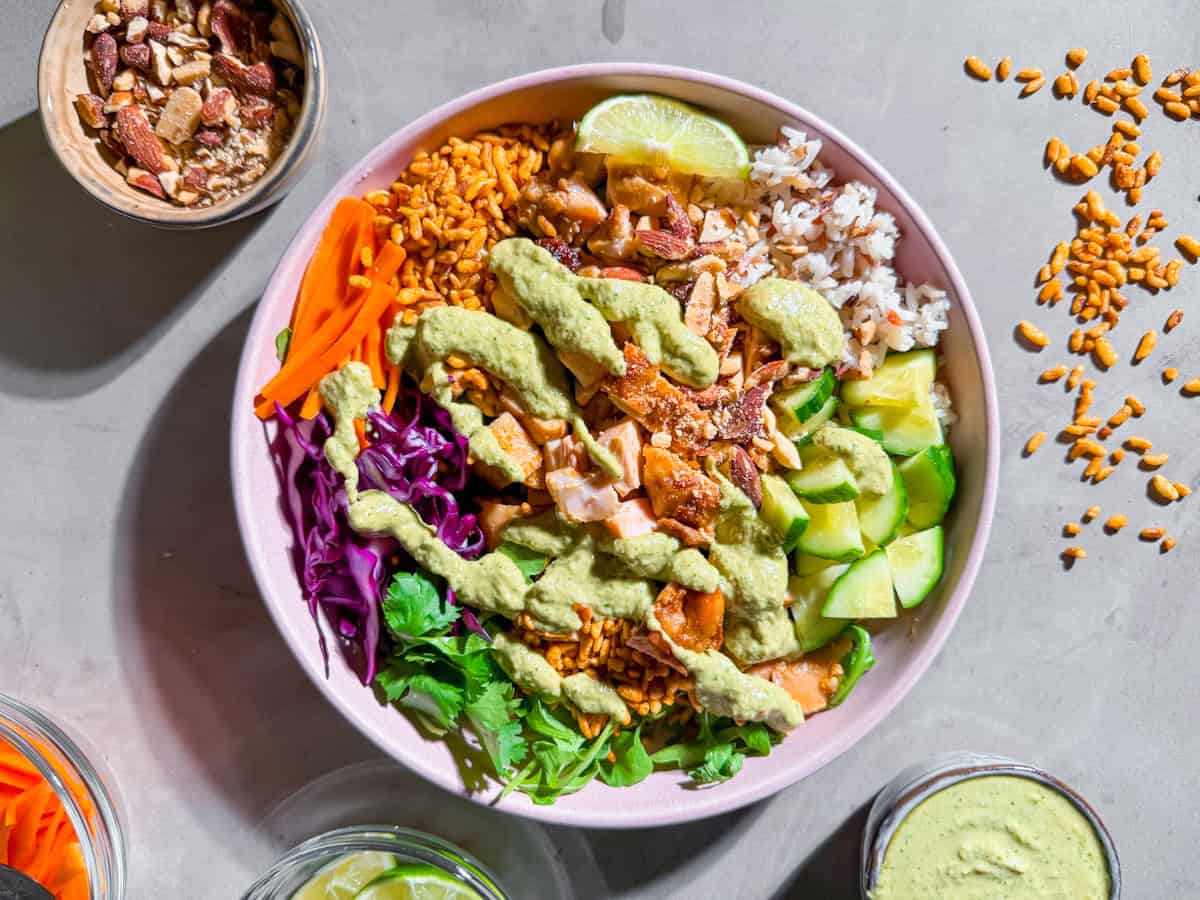 Finished Sweetgreen crispy rice bowl with chicken, rice, veggies, and dressing drizzled on top.