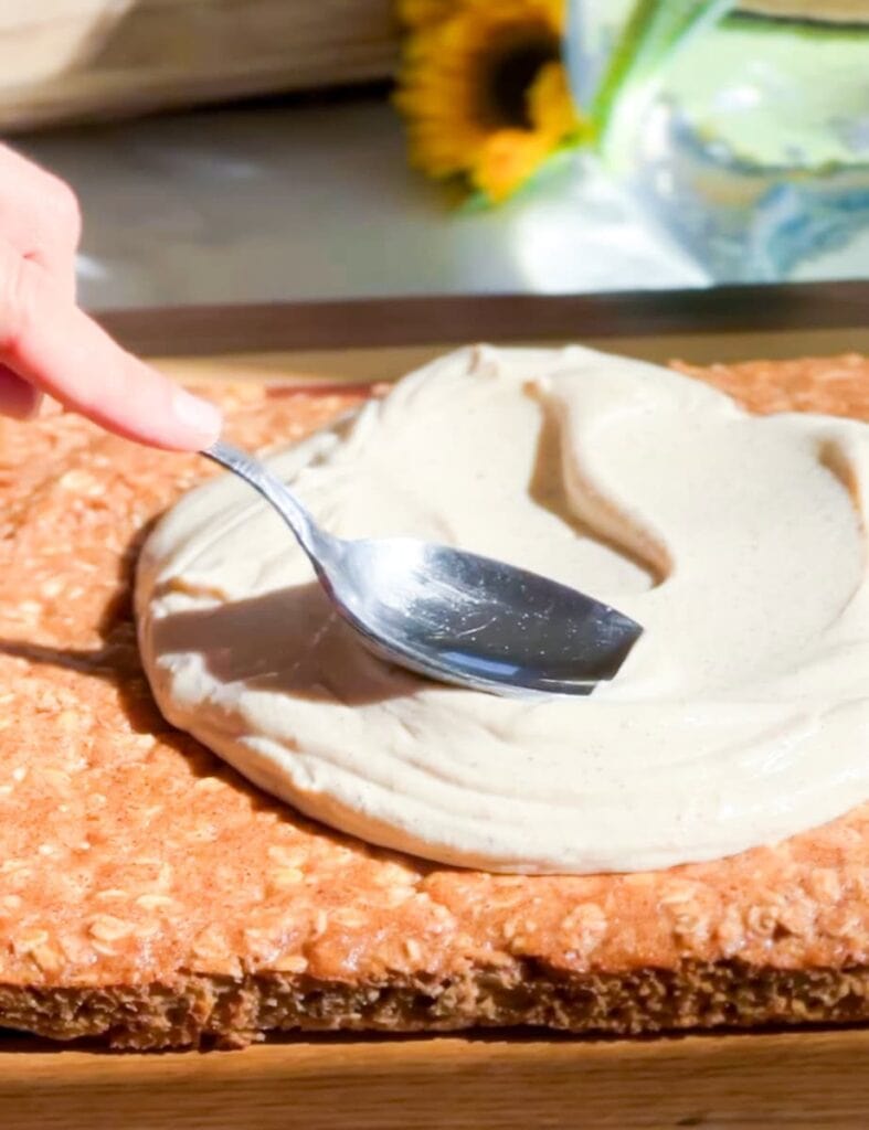 Frosting being spread on the biscoff baked oats.