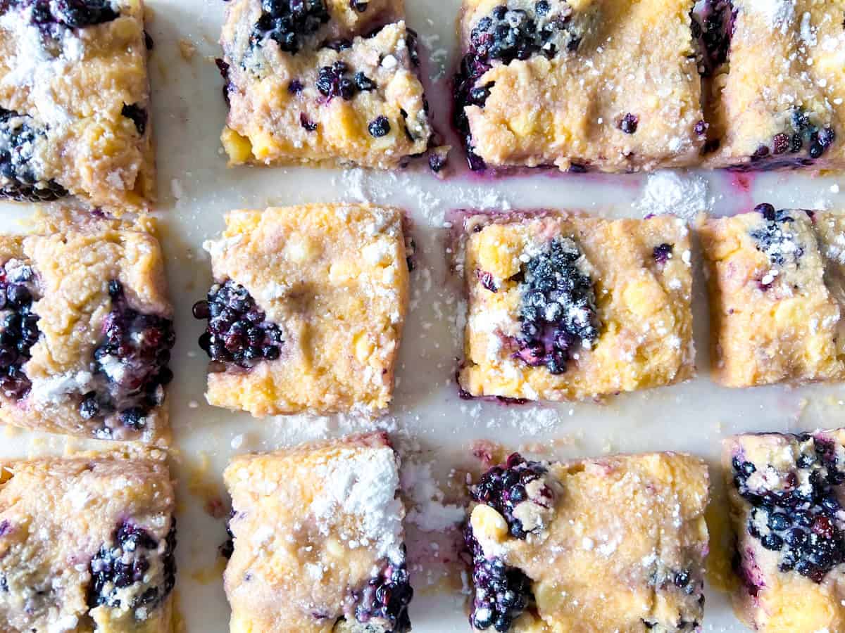 Sliced blackberry scones on parchment ready to be baked.