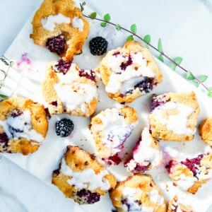 Baked blackberry scones drizzled with a glaze.