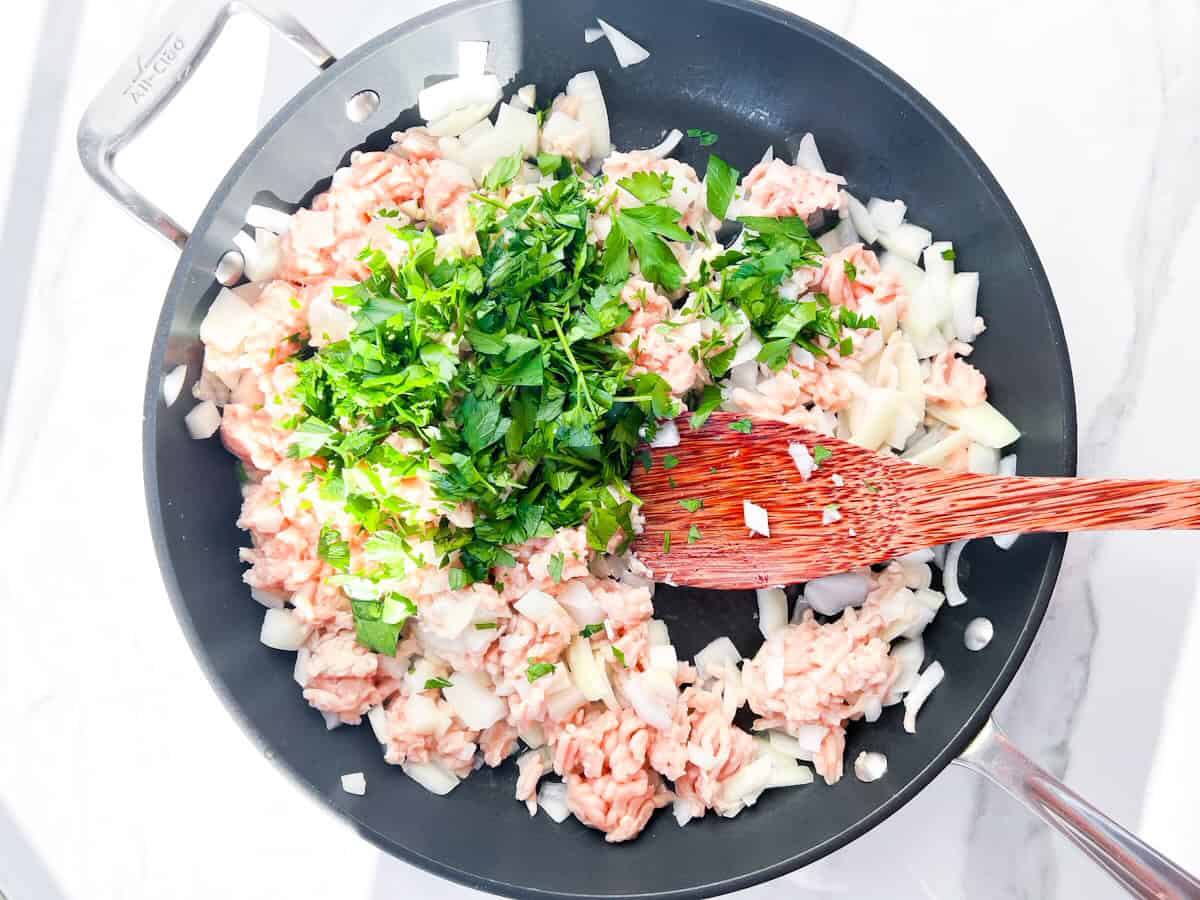 Ground chicken sautéing with onions & parsley.