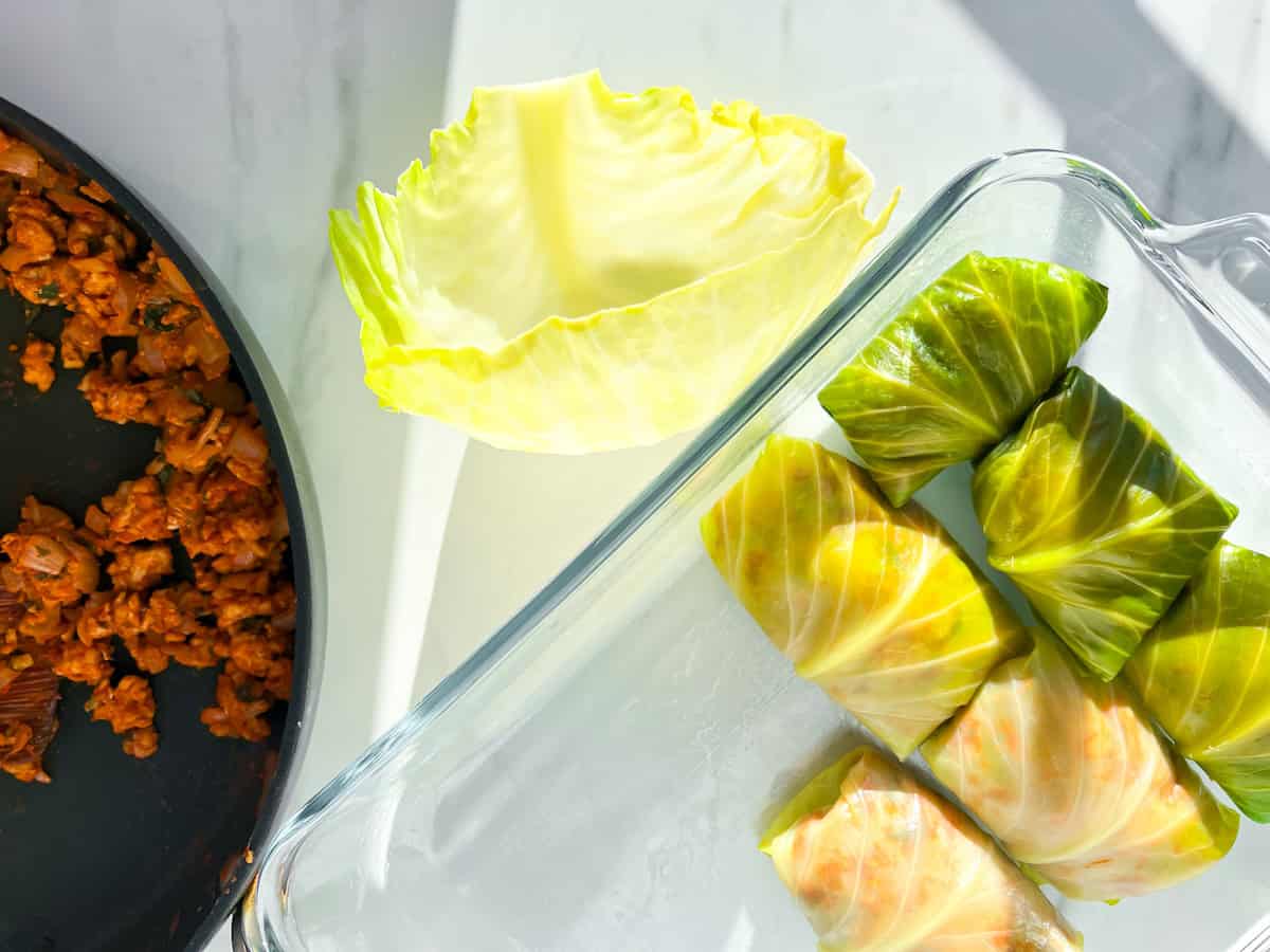 Malfouf filling next to a cabbage leaf and cabbage rolls.