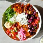 Cava style bowls with harissa chicken, hummus, arugula, and tzatziki.
