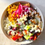 Cava bowl filled with mediterranean ingredients in a white bowl.