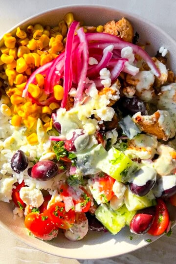 Cava bowl filled with mediterranean ingredients in a white bowl.