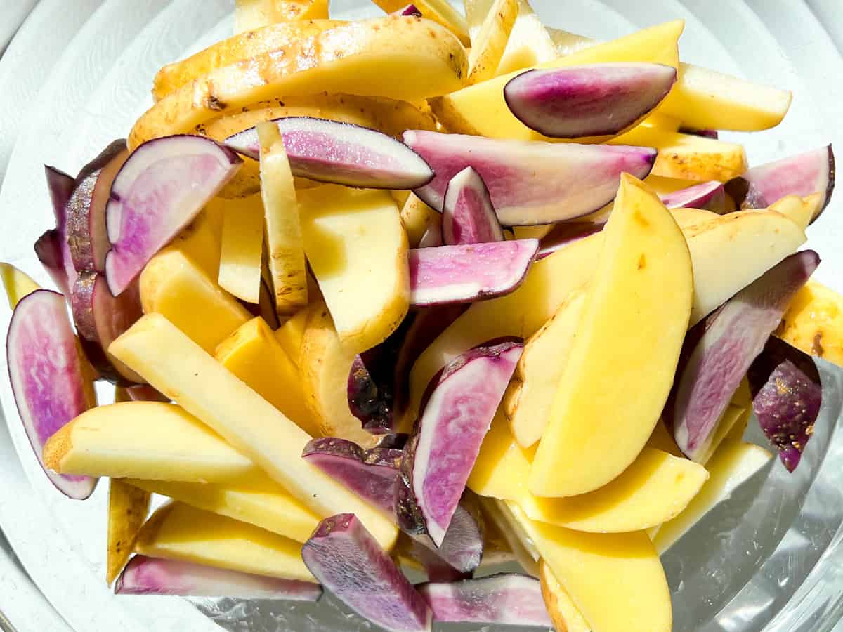 Potatoes cut and sitting in a large bowl.
