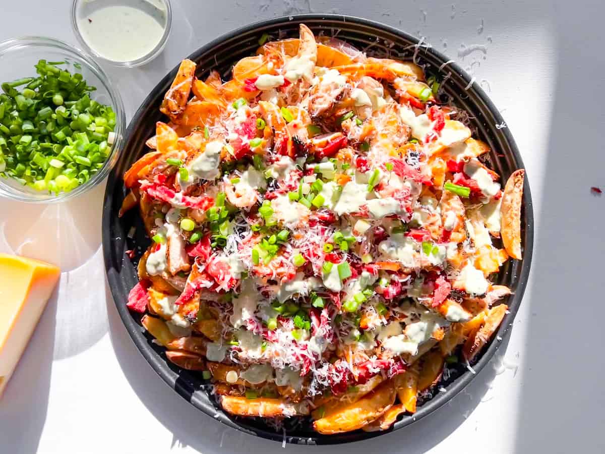 Finished loaded french fries on a big platter.