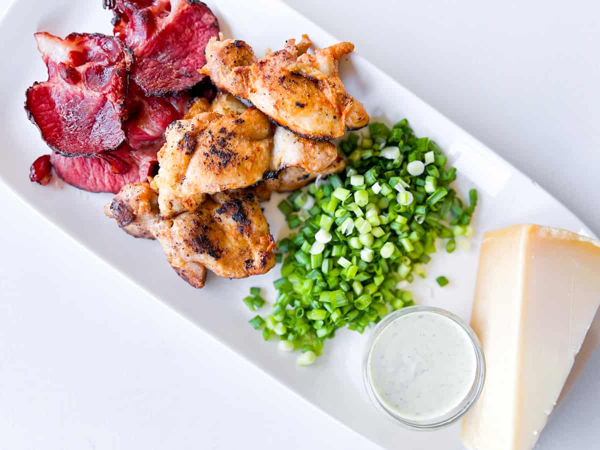 Loaded french fry toppings on a white plate.
