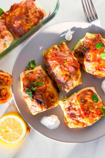 Lebanese cabbage rolls on a plate with greek yogurt.