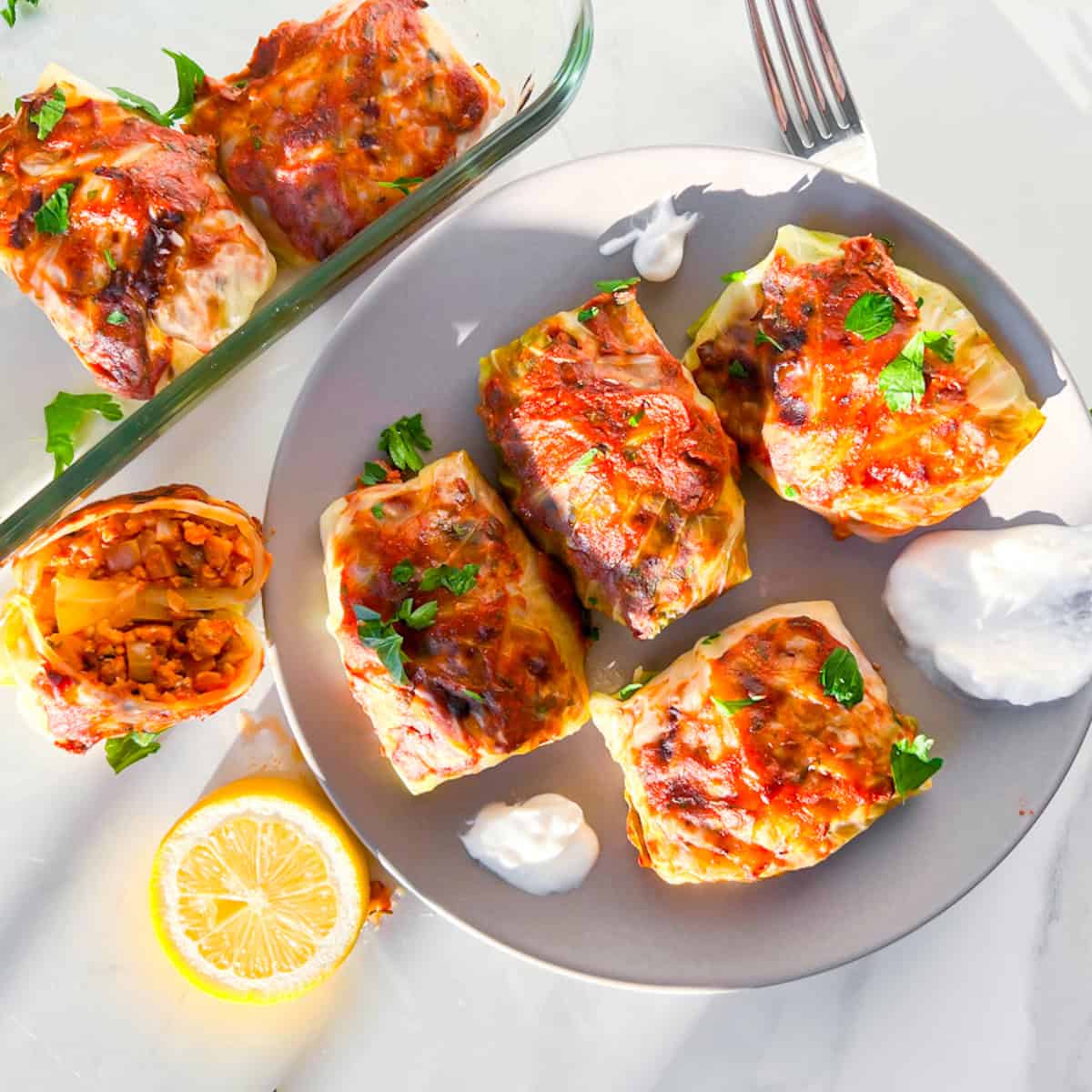 Lebanese cabbage rolls on a plate with greek yogurt.