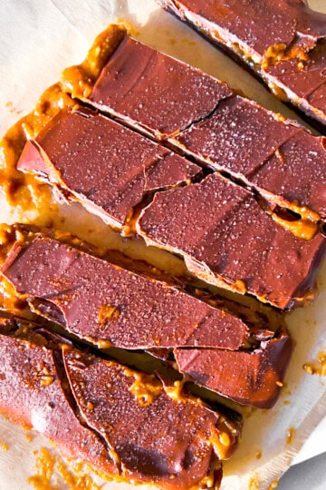 Dates covered in peanut butter and chocolate parchment paper.