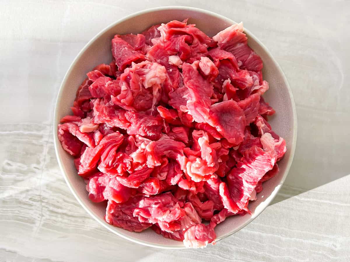 Sliced flank steak in a bowl.