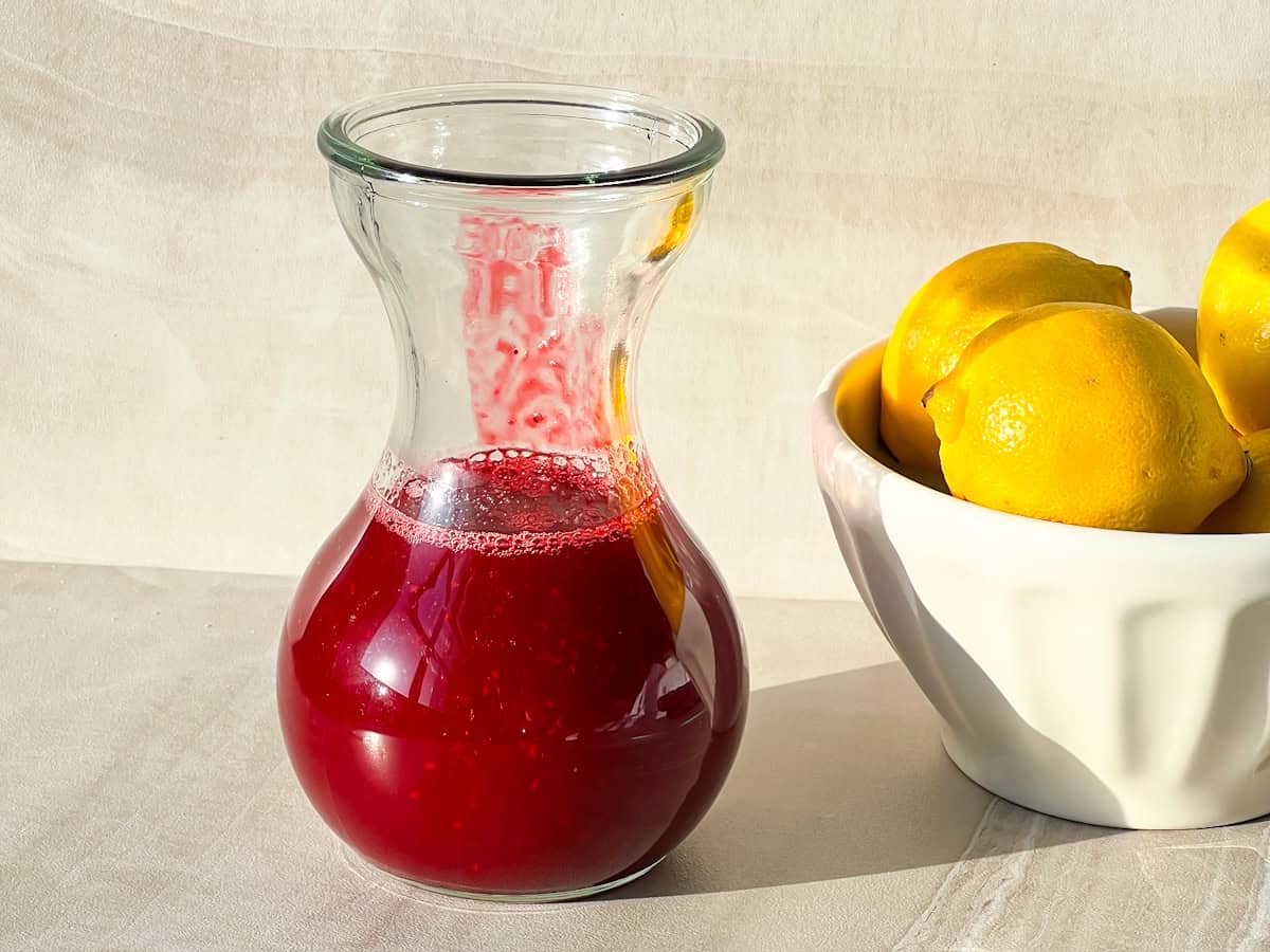 Strained cranberry syrup in a jar.