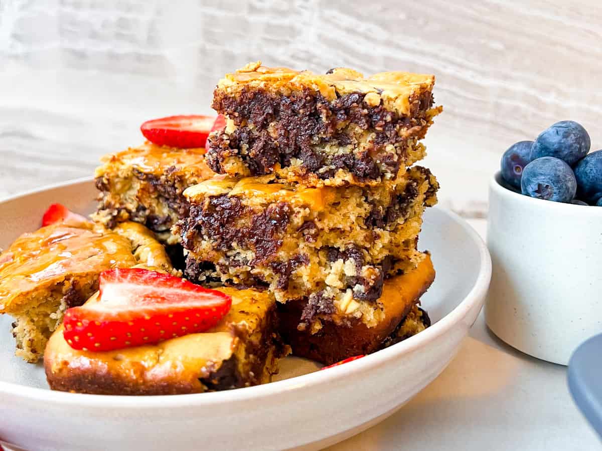 Finished baked oats on a plate served with fresh fruit on top.