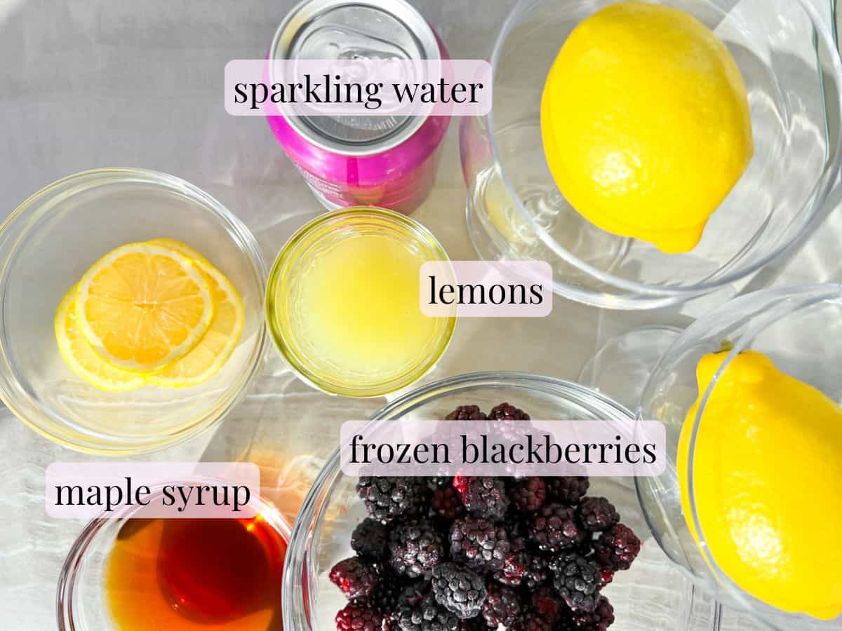 Ingredients for a blackberry mocktail in bowls and labeled.