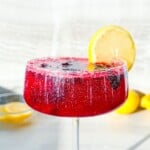Finished blackberry lemon mocktail garnished with a lemon slice.