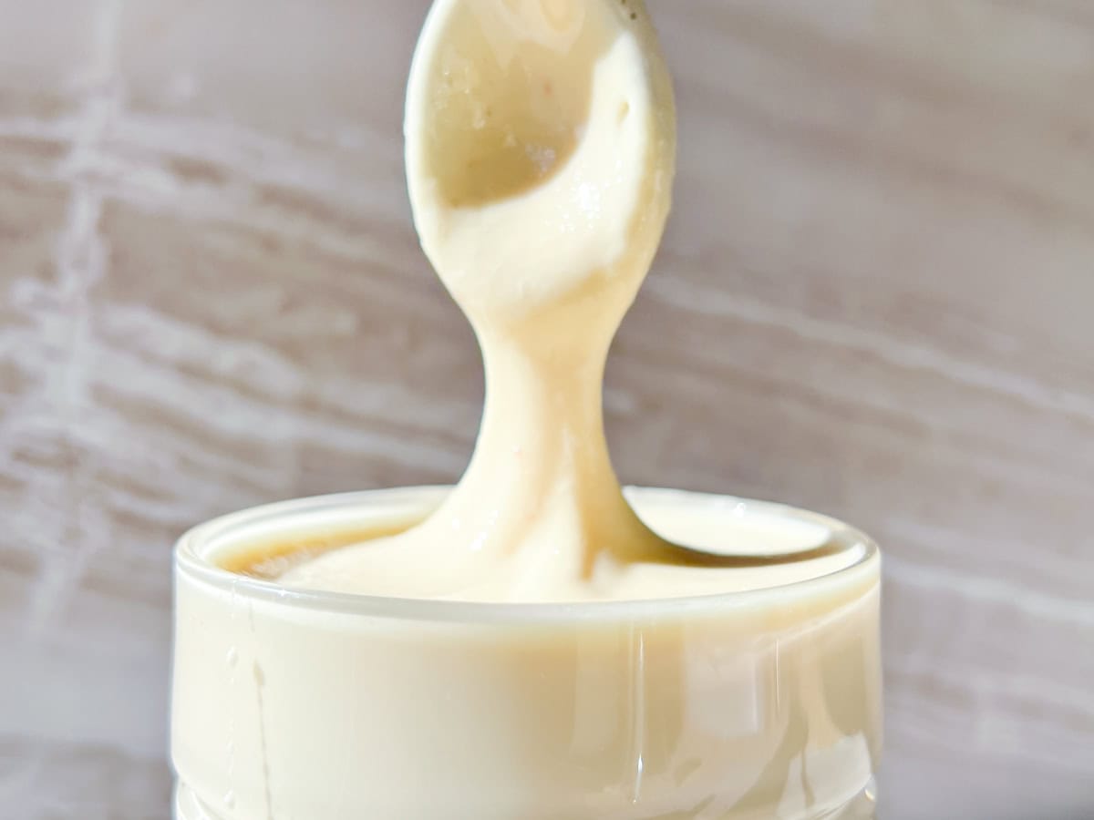 Creamy whipped honey in a jar with a spoon.