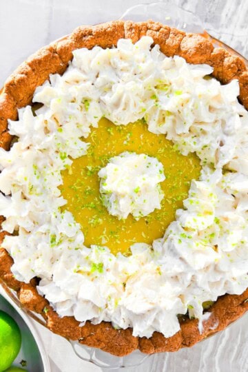 Key lime pie with a bowl of limes next to it.
