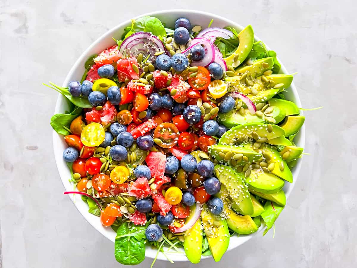 Finished spinach and arugula salad topped with all the ingredients.