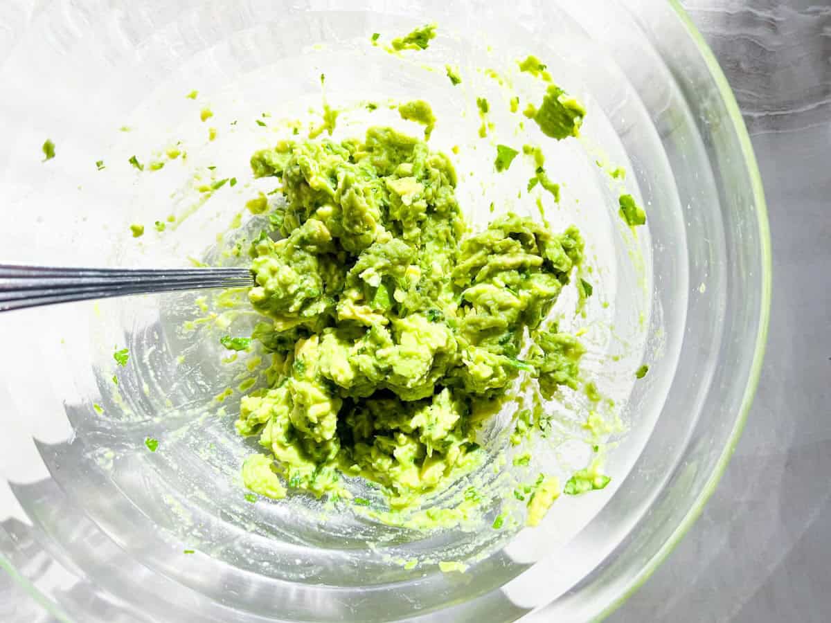 Mashed guacamole ingredients.