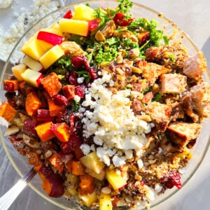 Sweetgreen harvest bowl with chicken, roasted sweet potatoes, goat cheese in a clear bowl.