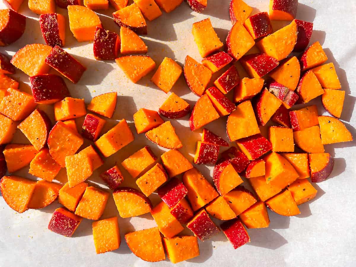 Sweet Potatoes cubed on parchment paper.