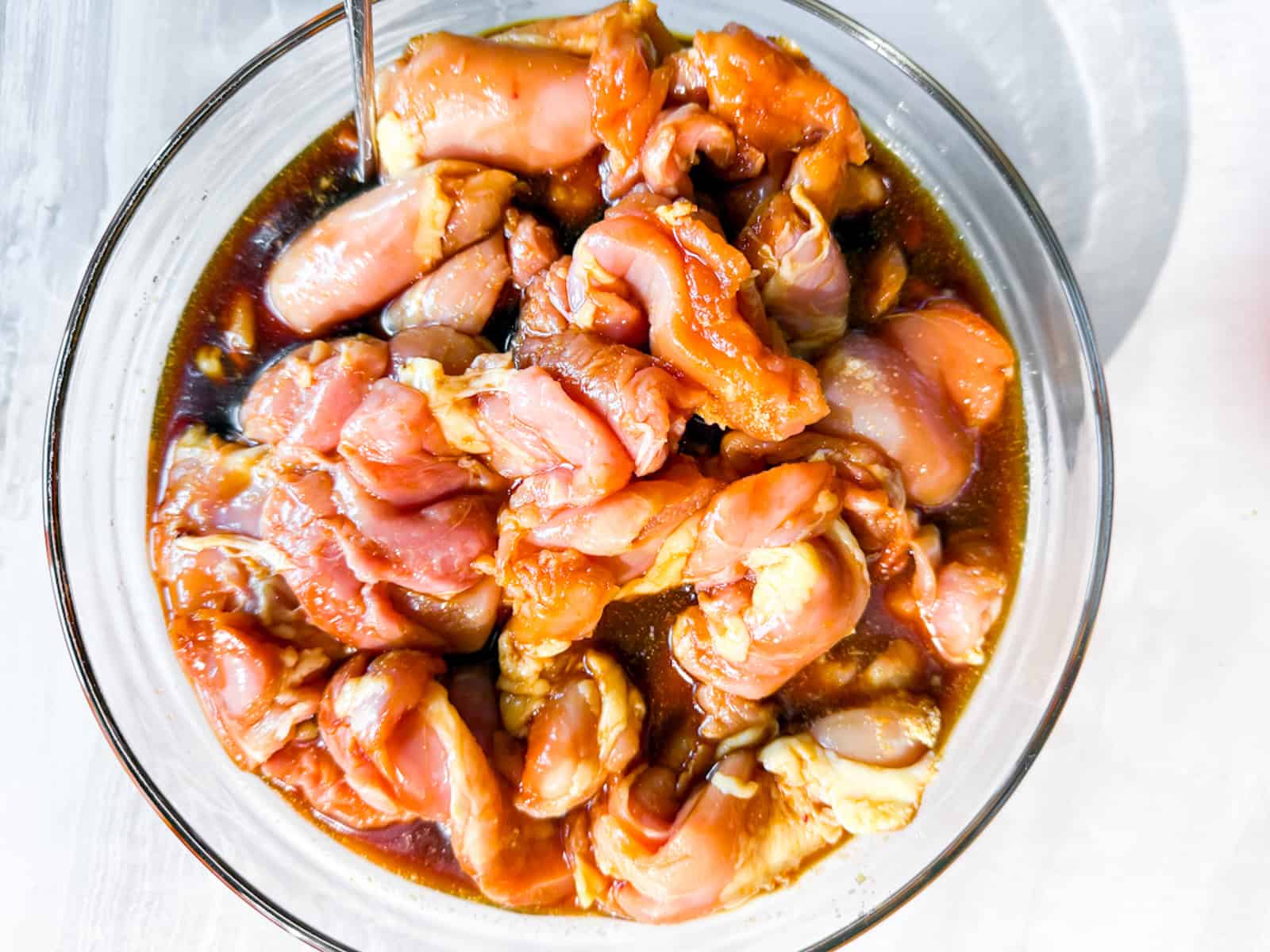 Chicken thighs marinading in teriyaki sauce.