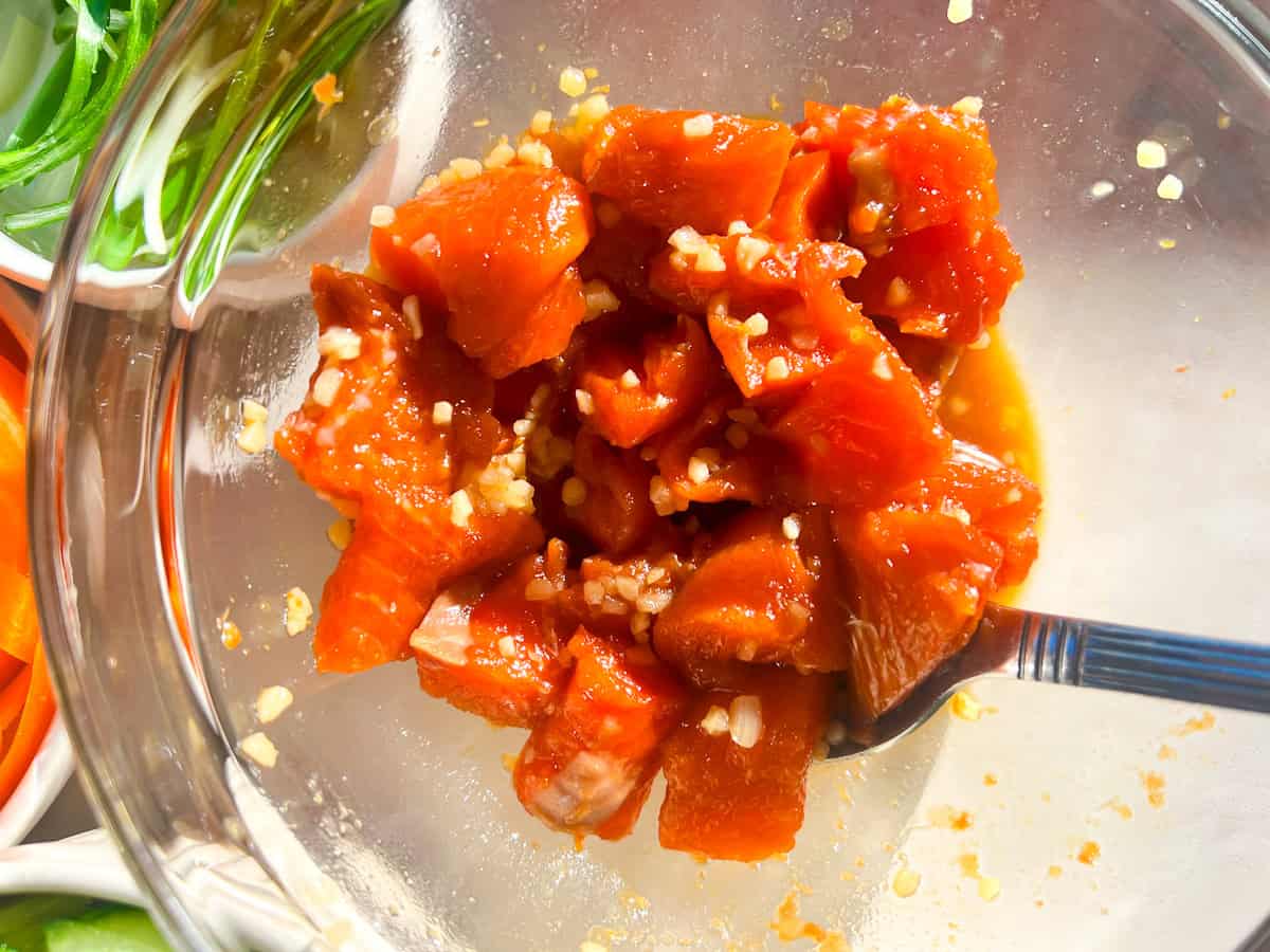 Cubed salmon in poke marinade.