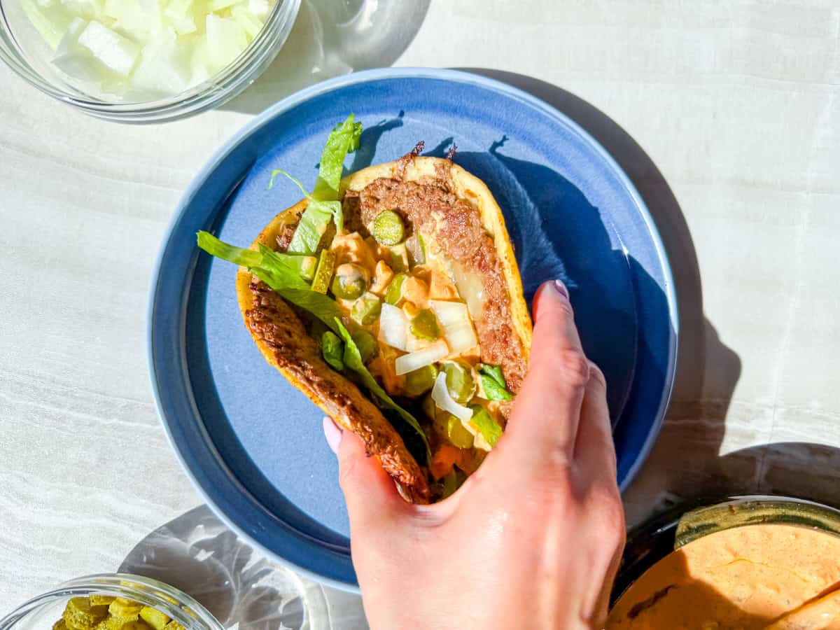 Hand holding a fully assembled big mac taco.