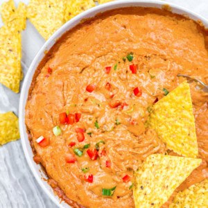Creamy cottage cheese queso with a chip dipped in the queso.