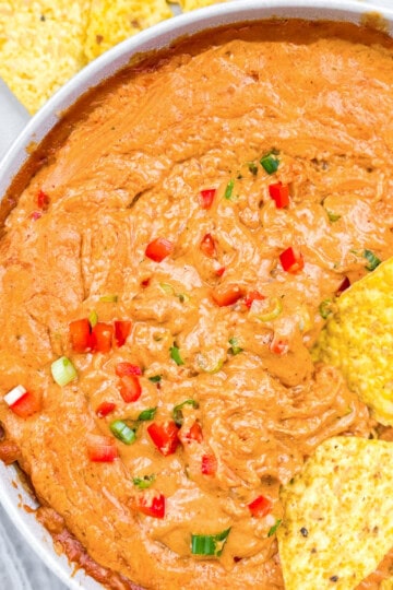 Creamy cottage cheese queso with a chip dipped in the queso.