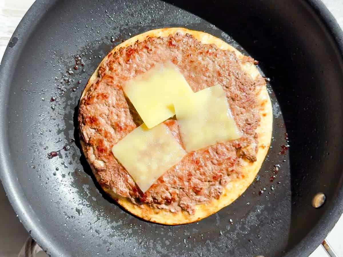 Big mac taco in a pan with cheese melting.