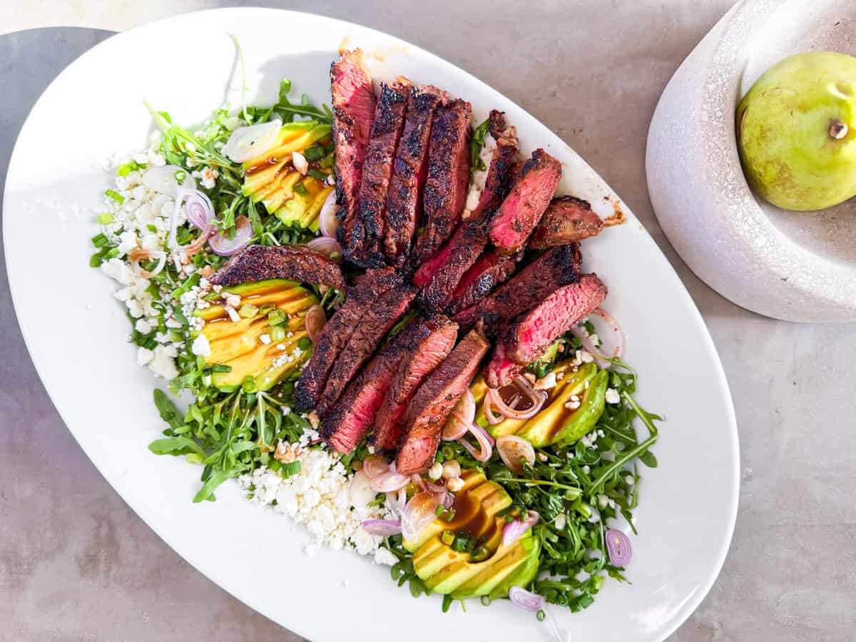 Steak arugula salad on a large platter.