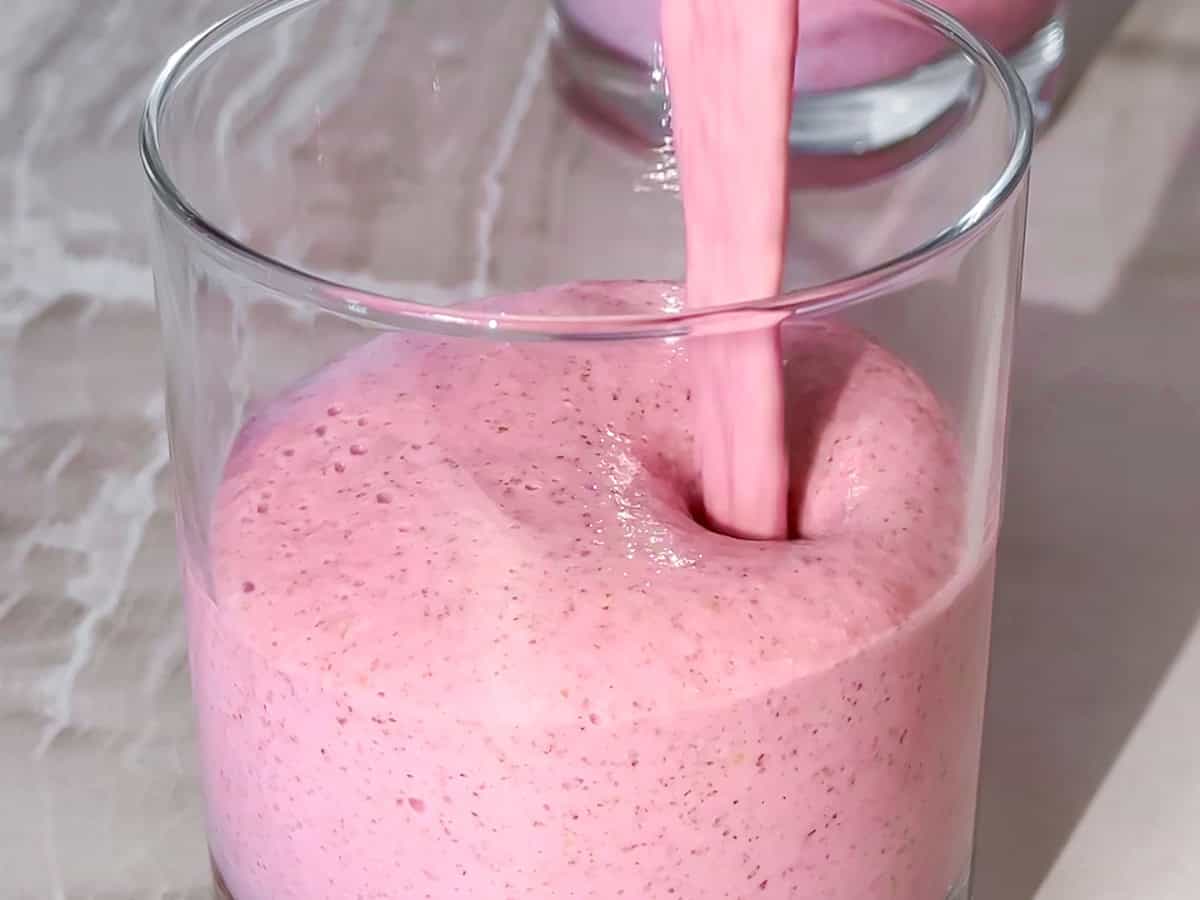 Chia pudding mixture being poured into a cup.